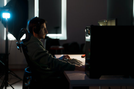 Focused cybersport gamer playing video game on computerの写真素材