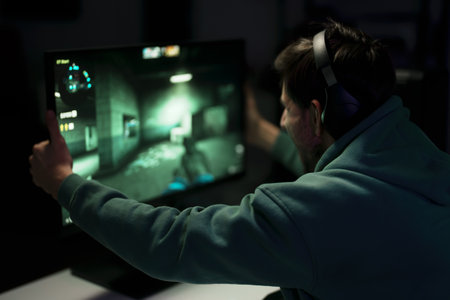Happy male cybersport gamer embracing monitor while rejoicing over victory
