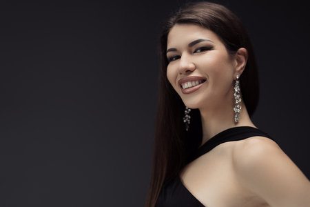 Smiling woman with makeup and earringsの写真素材