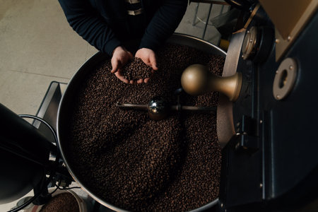 Crop man with handful of coffee beansの写真素材