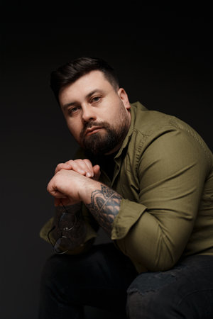 Sad young man holding glasses in his handの写真素材