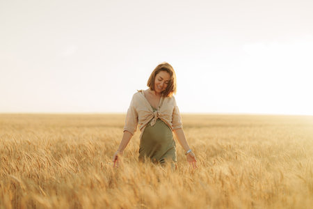 Positive young woman walking through grass fieldの写真素材