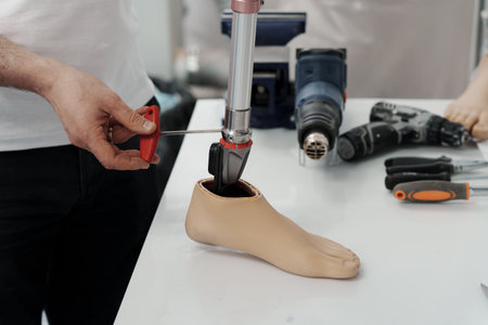 Master screwing and tightening metal part of modern prosthetic legの写真素材