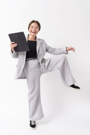 Energetic Businesswoman with Tablet in Motionの写真素材