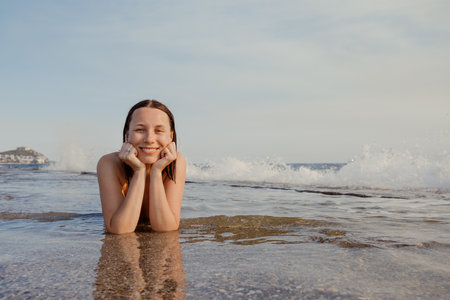 Serene Moment at the Sea: Woman Lying on Shoreの写真素材
