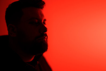 Man in Red Neon Glow: Introspective Moodの写真素材
