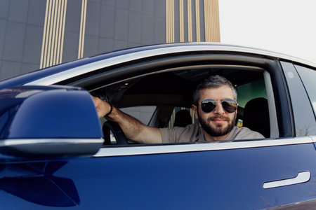 Confident man driving a sleek electric car in the city