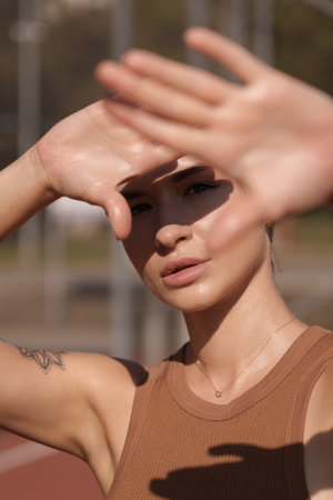 Young woman shielding eyes from sunlight outdoorsの写真素材