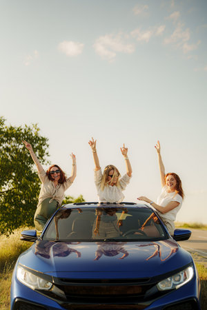 Joyful friends celebrating on a road trip at sunset