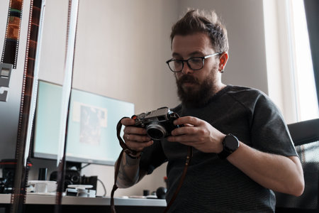 Photographer reviewing images on vintage camera indoors