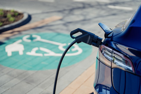 Electric car charging at a station with green parking spotの写真素材