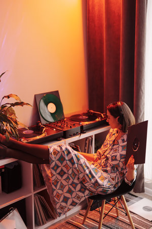 Relaxed young woman enjoying music on vinyl record playerの写真素材
