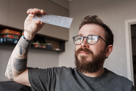 Photographer analyzing film negatives at homeの写真素材