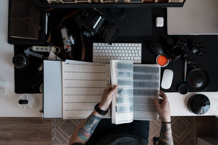 Photographer reviewing negatives at a modern desk setupの写真素材