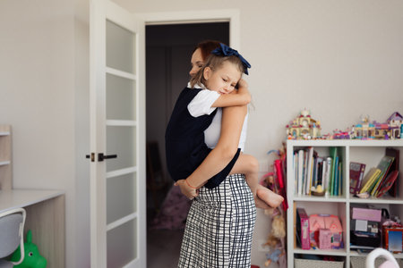 Mother Hugging Daughter in Cozy Roomの写真素材