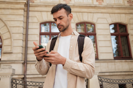Young man using smartphone outside historical buildingの写真素材