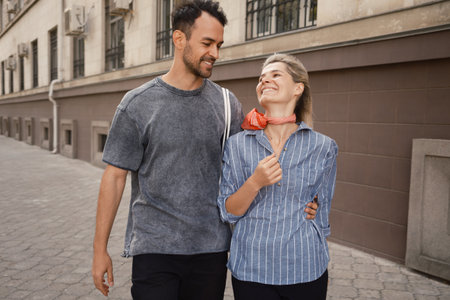 Happy couple walking and laughing on a city streetの写真素材