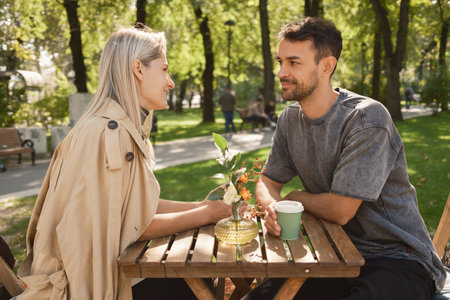 Couple enjoying coffee on a sunny day in the parkの写真素材