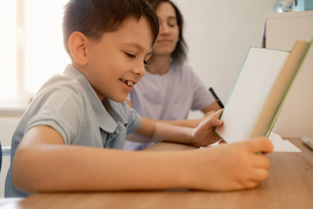 Mother helping young son with homework at the table