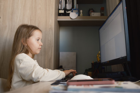 Young girl using a computer at home for study or leisureの写真素材