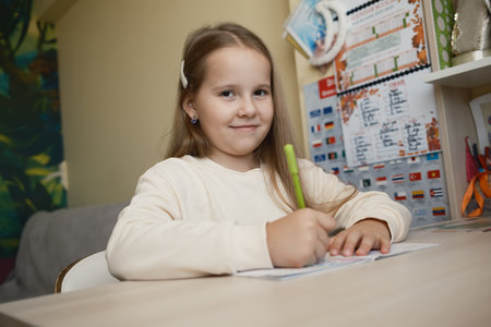 Young girl studying at her desk with enthusiasm and focus