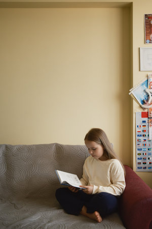 Young girl enjoying a quiet moment reading a book in a cozy space