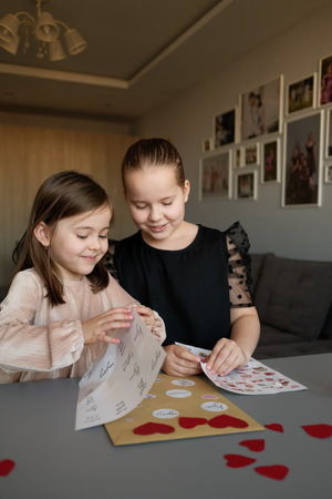 Two children creating heart-themed crafts together at home