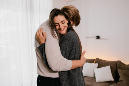 Couple Embracing in a Cozy Home Setting With Warm Smilesの写真素材