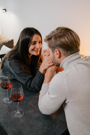 Couple sharing a romantic moment at a table with wine glassesの写真素材
