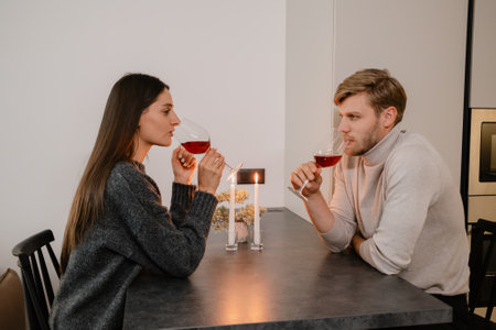 Couple enjoying a romantic evening with wine and candlelight at homeの写真素材