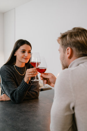 Couple enjoying a romantic moment sharing wine at a cozy dining settingの写真素材