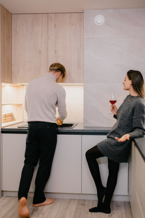 A couple enjoying time together in a modern kitchen settingの写真素材