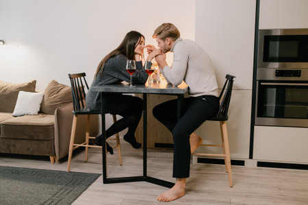 Couple enjoying a romantic dinner together at home in a cozy settingの写真素材