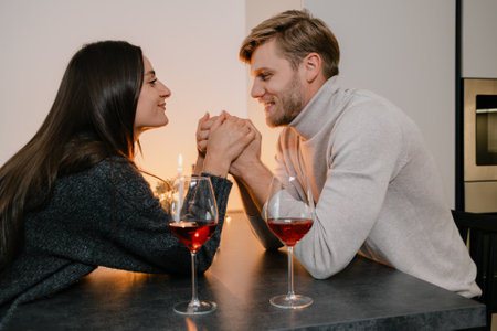 Romantic couple enjoying wine together at a cozy and intimate table settingの写真素材