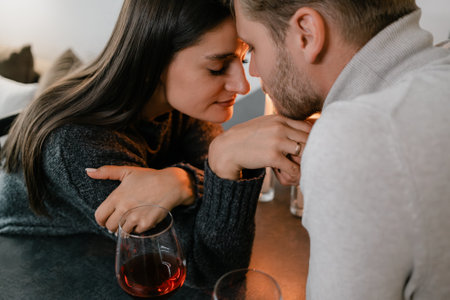 Romantic couple enjoying an intimate moment during dinner with red wineの写真素材