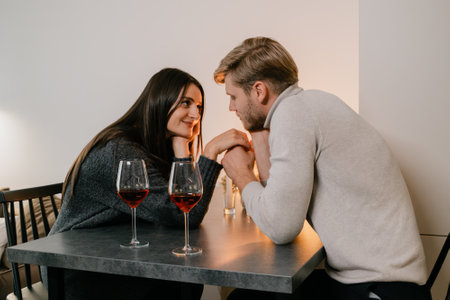 Romantic couple enjoying a cozy moment together at a candlelit dinner tableの写真素材