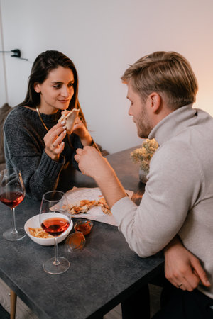 Couple Enjoying Dinner Together with Wine and Conversation in Cozy Settingの写真素材