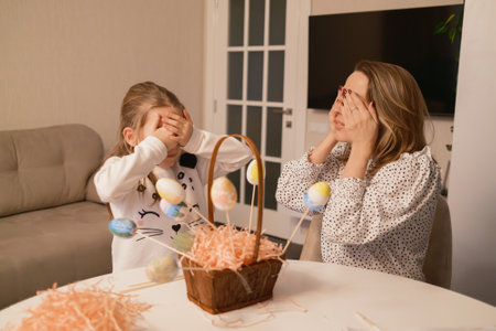 Mother and daughter celebrating Easter with decorated eggs and festive joyの写真素材