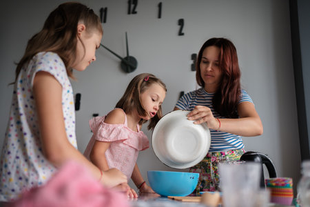 Mother and daughters baking together in modern kitchen