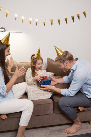 Family celebrating a special occasion with surprise gift and festive decorationsの写真素材