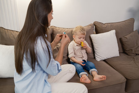 Mother helping her young childの写真素材