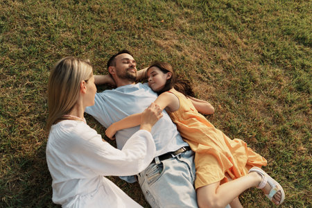 Happy family relaxing on a sunny day in a grassy fieldの写真素材