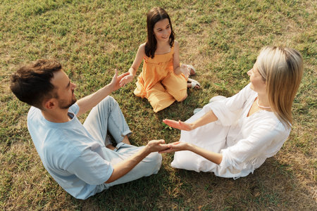 Happy family bonding and communicating outdoors in a peaceful park settingの写真素材