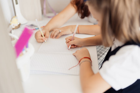 Mother and Daughter Writing Together at Homeの写真素材