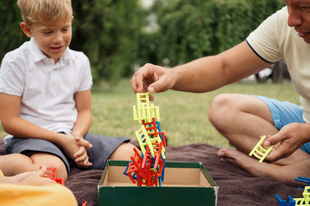 Father and son enjoying outdoor stacking game togetherの写真素材