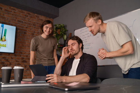 Team collaboration examining progress results during a casual office discussionの写真素材
