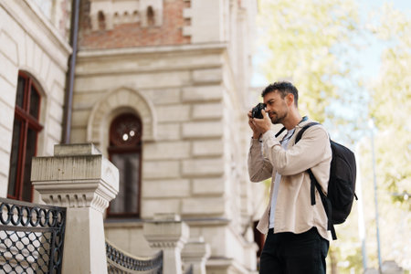 Young tourist capturing architectural details with camera outdoorsの写真素材