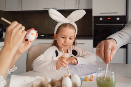 Family decorating Easter eggs together at home in a festive atmosphereの写真素材