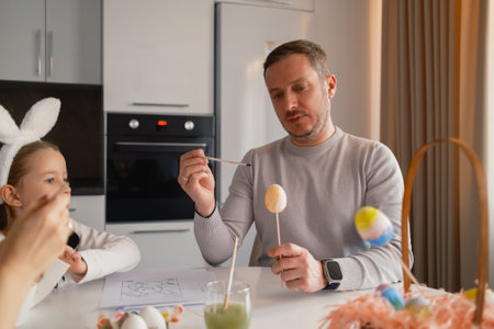 Family decorating Easter eggs with fun and creativity in a modern kitchenの写真素材
