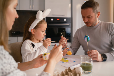 Family painting Easter eggs together at home in a festive atmosphereの写真素材